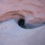 Deep hole, still holding water, drilled in sandstone floor of canyon by water current